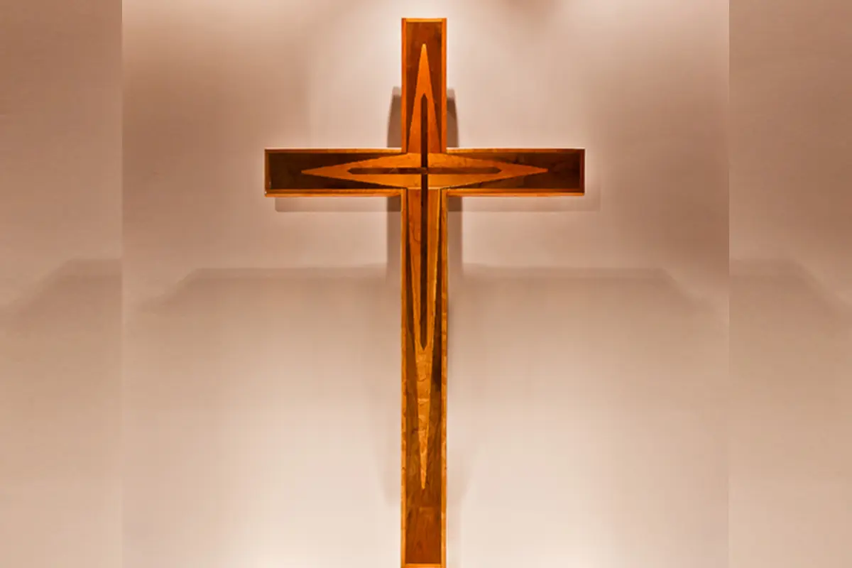 A glowing wooden cross illuminated against a soft background.