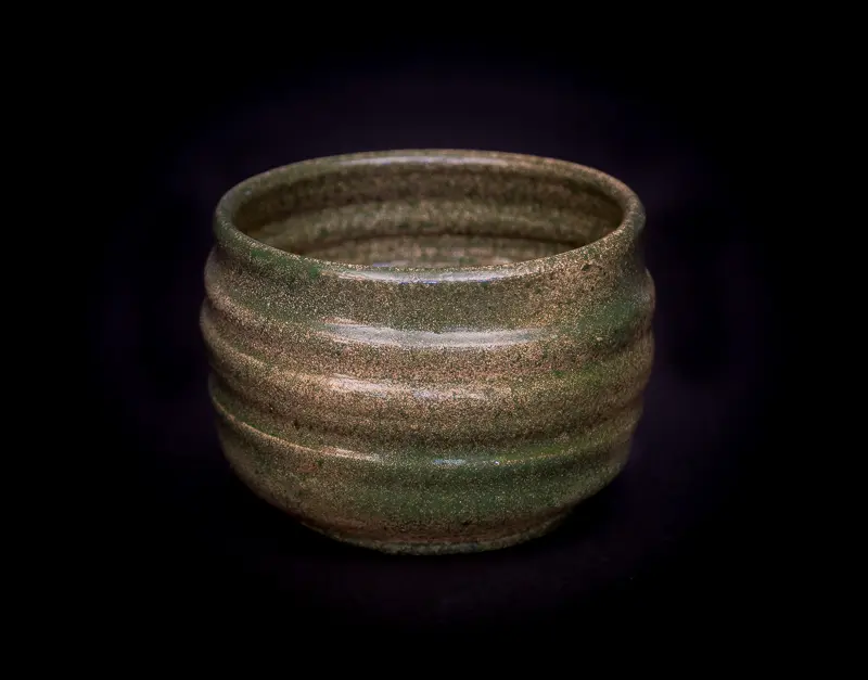 A rustic, earth-toned ceramic bowl with a textured finish.