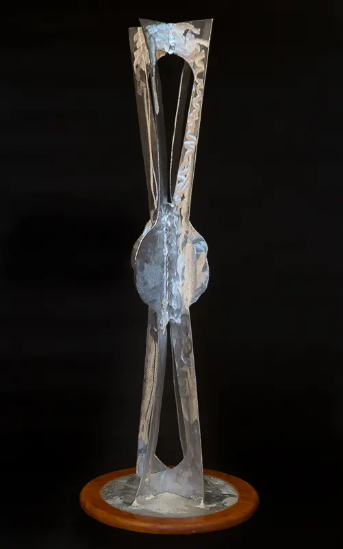 Close-up of metal tweezers holding a small, translucent pebble against a black background.