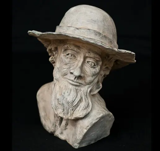 Bust sculpture of an elderly man with a hat and beard.