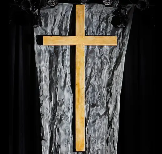 A golden cross on a textured black and gray background.