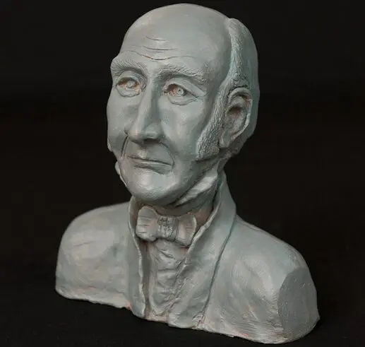 Sculpted bust of a distinguished man with a mustache and bow tie.