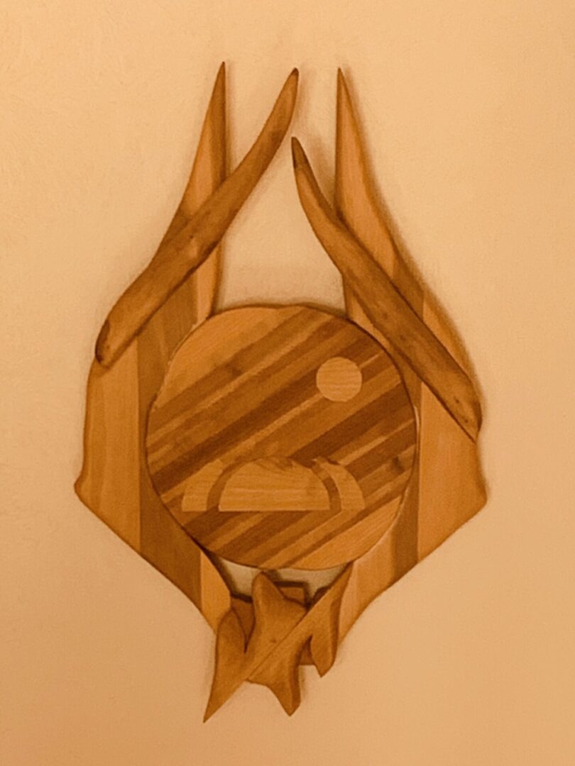 Wooden sculpture resembling a stylized animal head with geometric patterns.