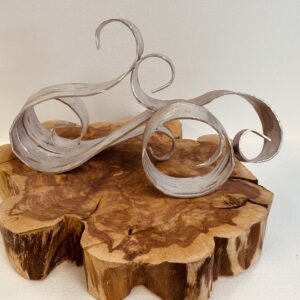Elegant wooden sculptures with flowing, ribbon-like curves on a natural wood base.
