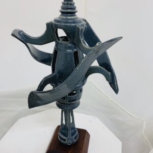 Abstract metal sculpture with dynamic curved elements on a wooden base.