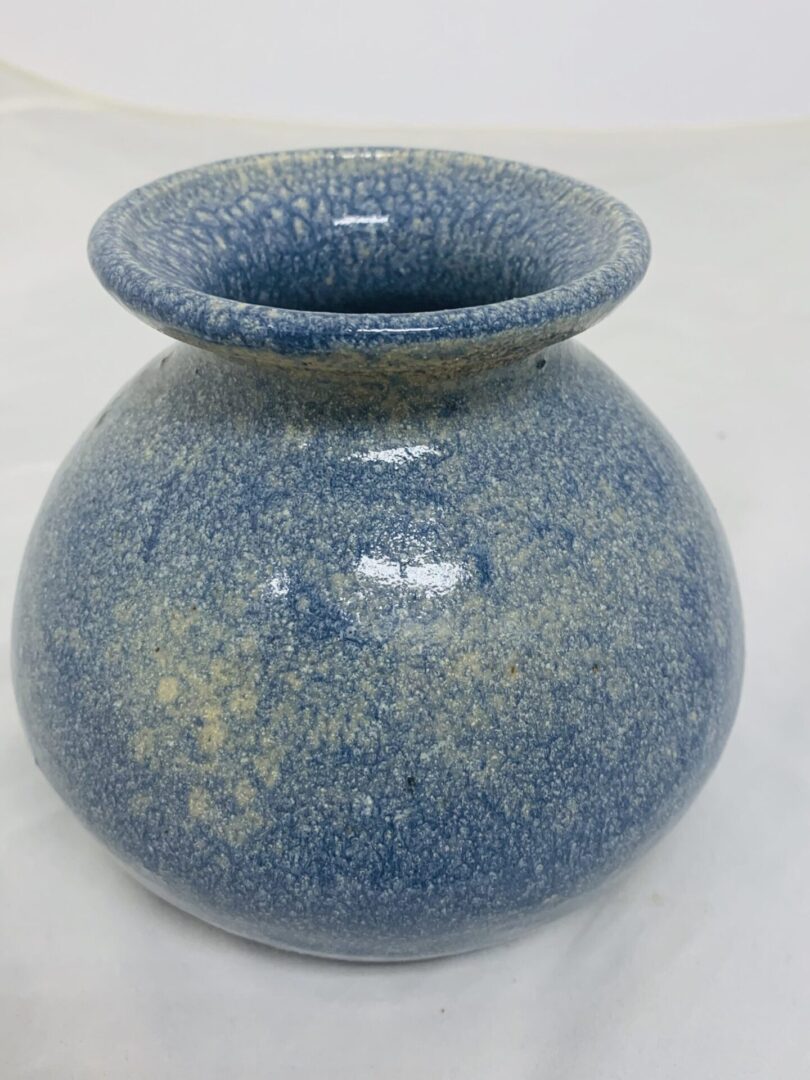 Round blue ceramic vase with a wide rim and speckled glaze.