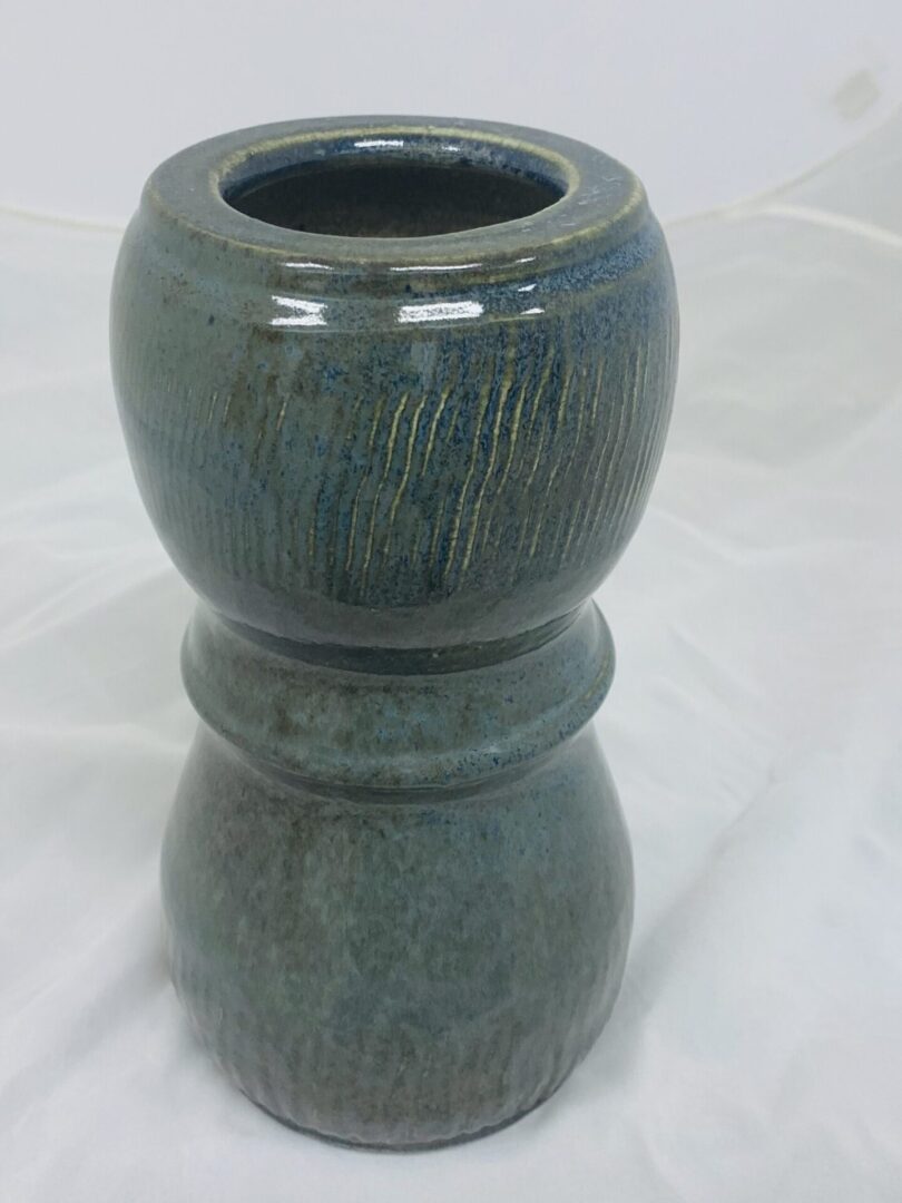 A smooth, dark green ceramic vase with a rounded top and rounded base.
