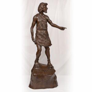 Bronze statue of a man in ancient attire standing on a rock.