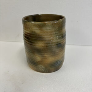 A small ceramic cup with earthy brown and green glaze.