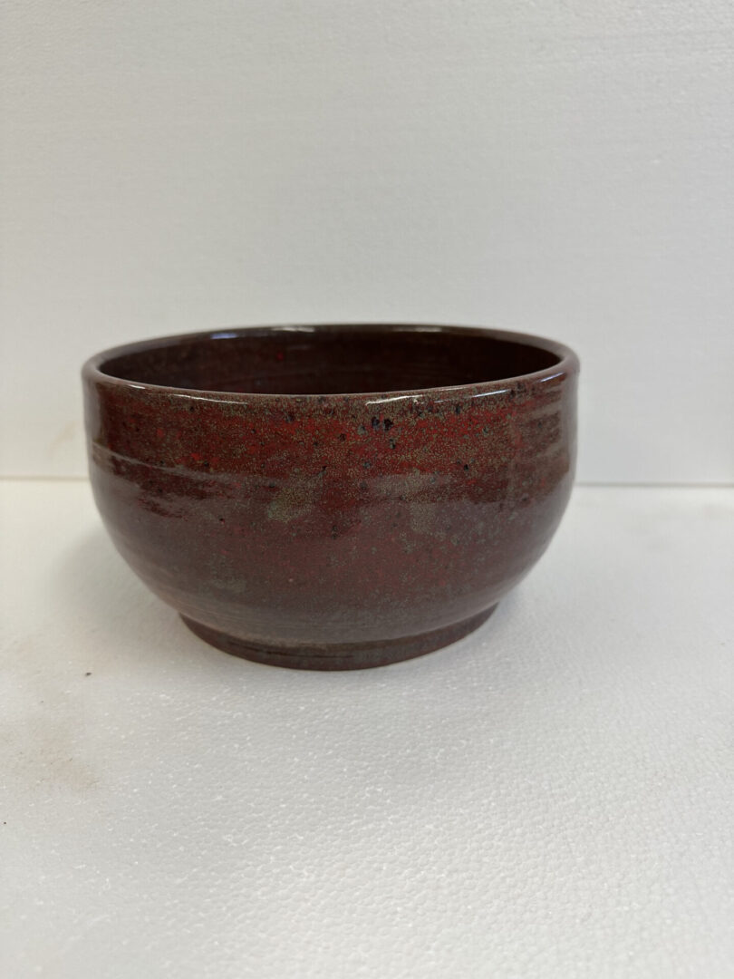 Brown ceramic bowl with a smooth finish on a white background.