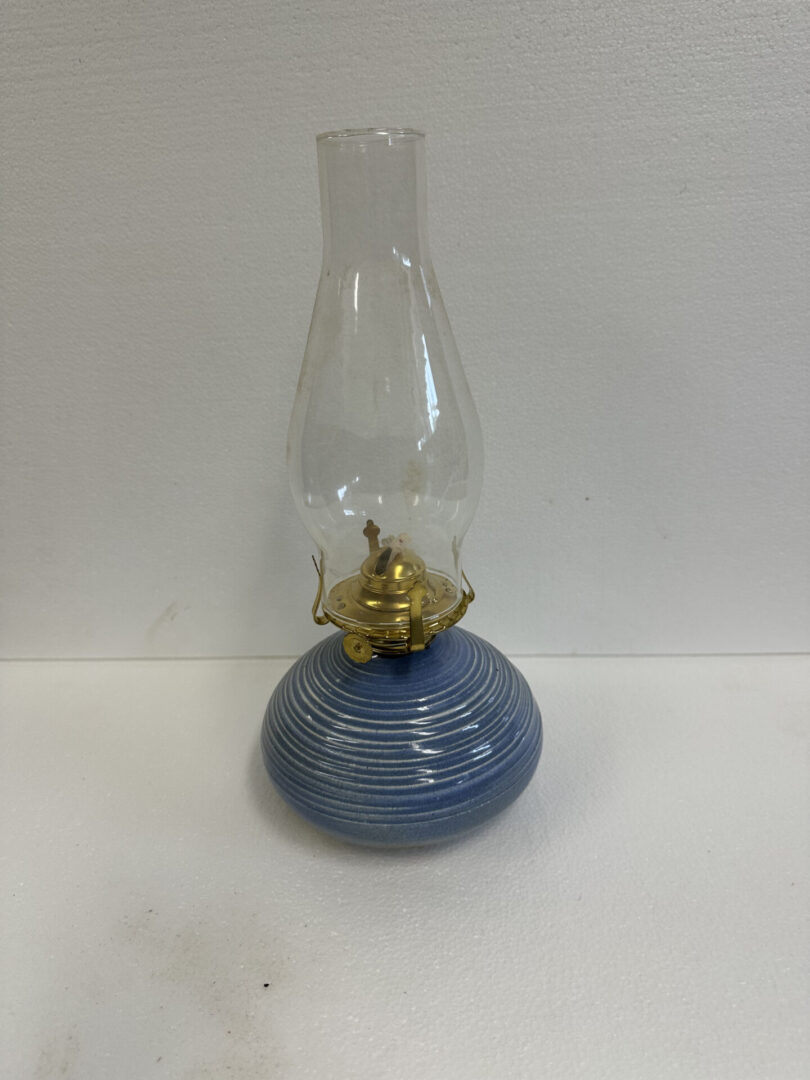 Vintage blue oil lamp with glass chimney on white background.