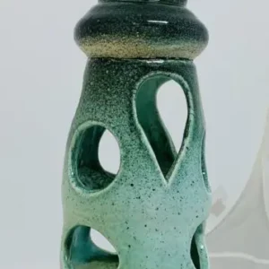 Green ceramic vase with multiple cut-out holes and a handle.